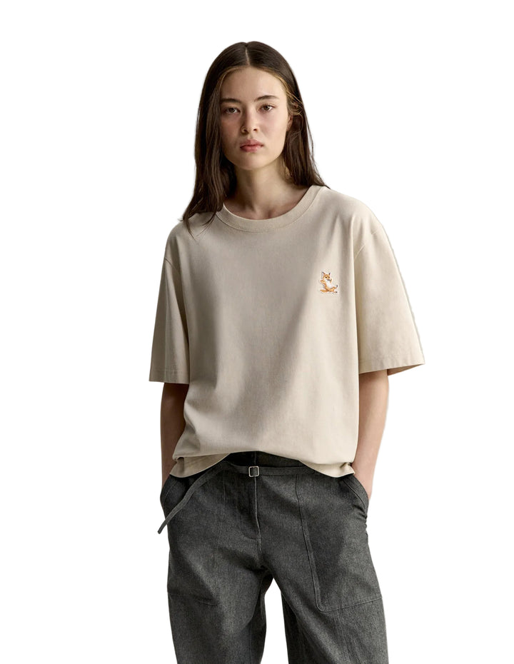 Modelo con camiseta Maison Kitsuné Chillax Fox beige y vaqueros, vista frontal