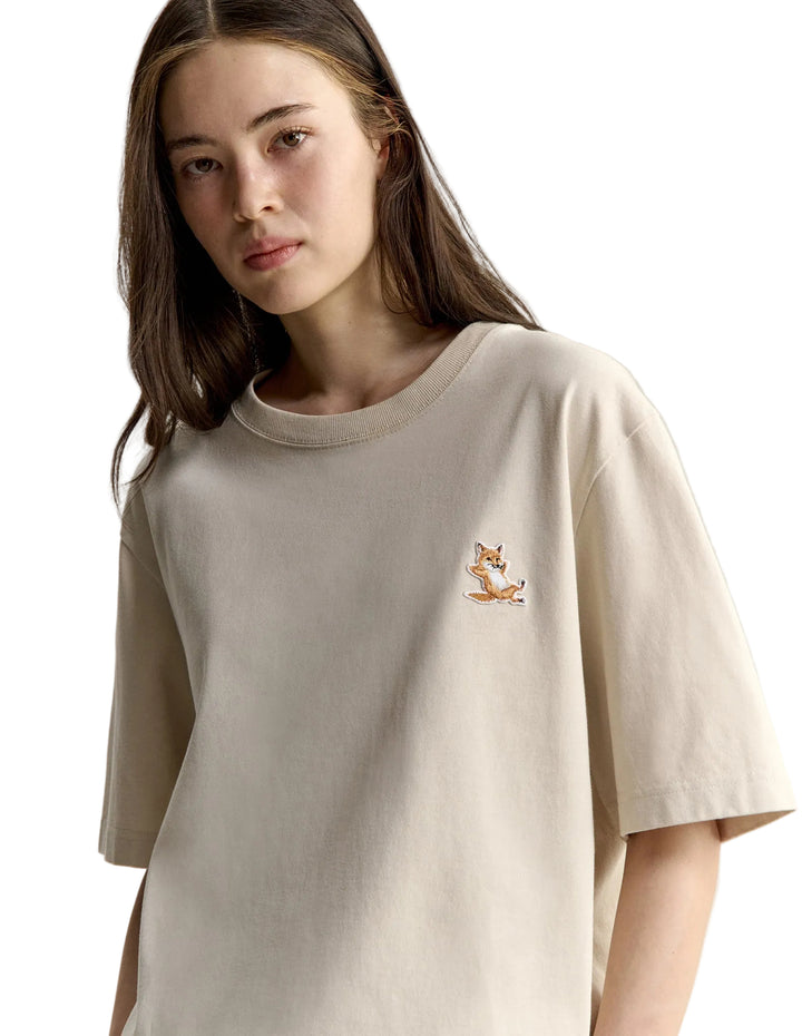 Modelo con camiseta Maison Kitsuné Chillax Fox beige, detalle del parche del zorro en el pecho