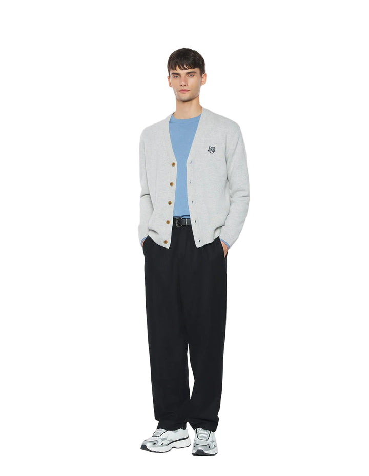 Modelo con cárdigan Maison Kitsuné Fox Head gris claro y pantalón negro, vista frontal