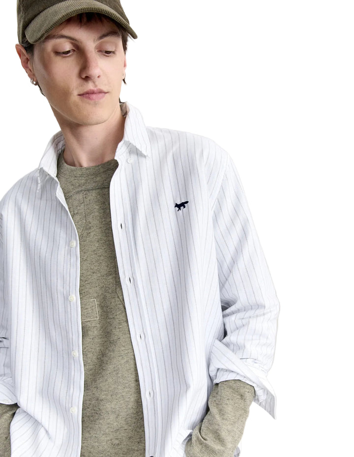 Modelo con camisa Maison Kitsuné Profile Fox abierta sobre camiseta, detalle del bordado del zorro